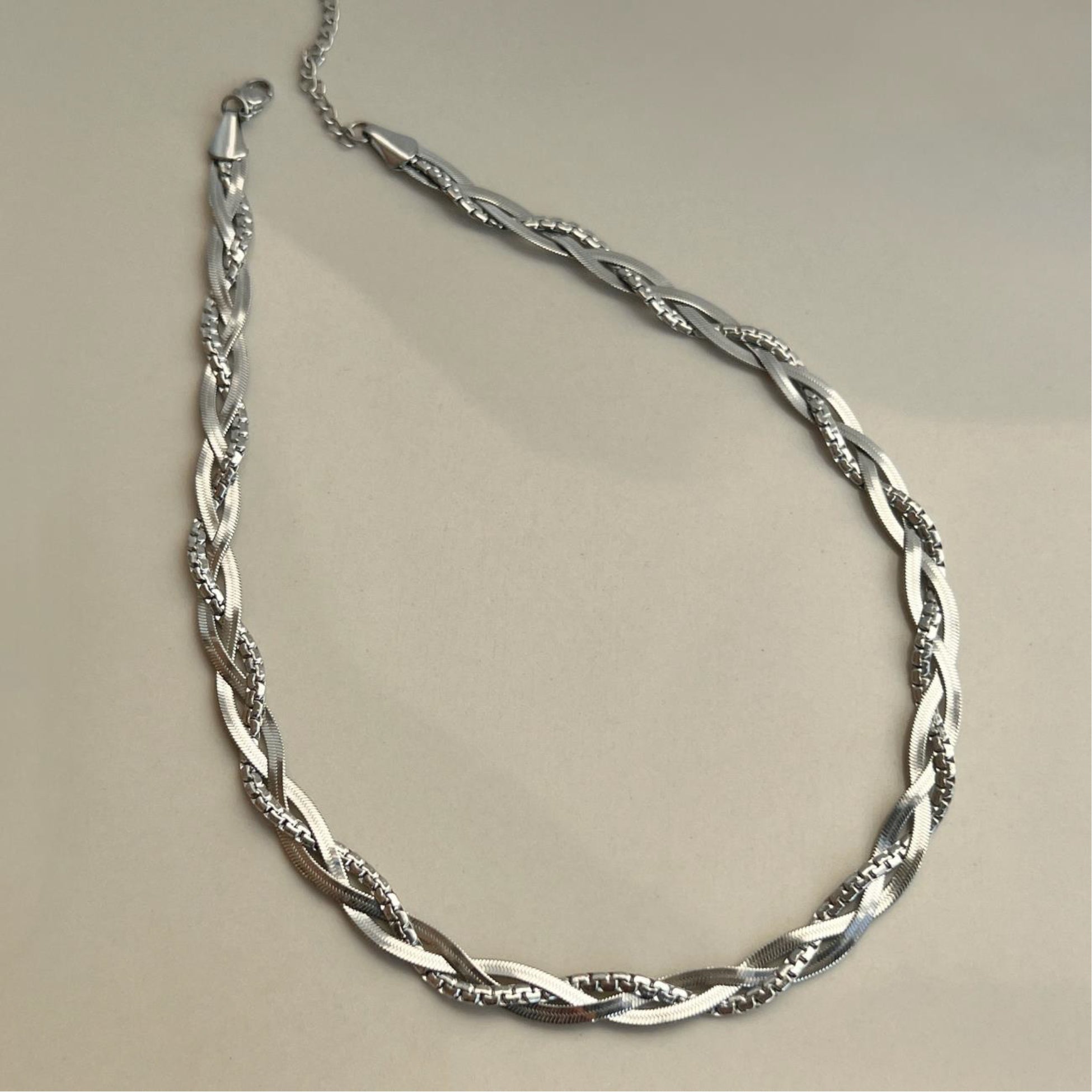 Silver necklace on a beige background